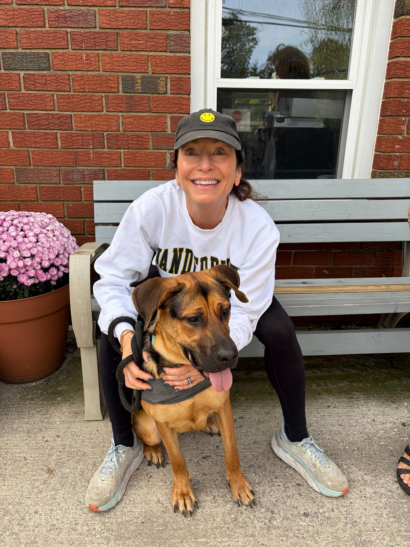 A woman sitting with a rescue dog on a bench during BERAURA’s Pet Rescue visit.